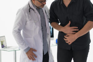 Doctor examining abdomen of patient for crohn's disease