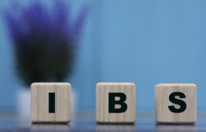 IBS - word on cubes on a blue background with lavender