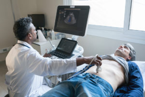 Doctor performing a stomach ultrasound on a patient