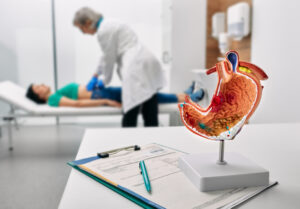 Doctor palpates woman patient abdomen and examines belly at clinic